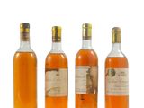 trois bouteilles de vin sont alignées sur une surface blanche