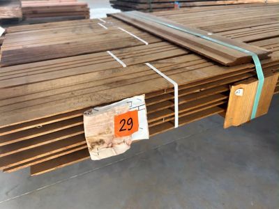plusieurs pièces de bois sont empilées dans un entrepôt
