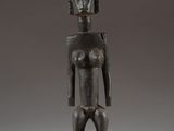 an image of a statue of a woman standing on a wooden base