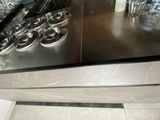 stainless steel counter top with cups of coffee on top of it