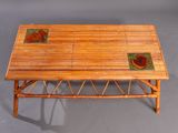 a small bamboo table with a tile top on a gray surface
