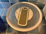 a toilet with a lid that has a cell phone in it