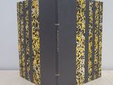 a black and yellow book sitting on top of a wooden table