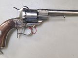 un gros plan d'un revolver posé sur une table, avec un cordon rouge