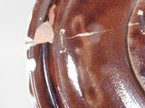 a close up of a brown plate on a white surface