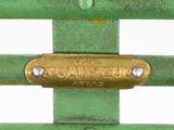 a close up of a green metal fence with a brass plate on it