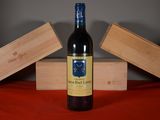 a bottle of wine sitting on a table next to two wooden boxes