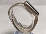 a silver apple watch sitting on top of a clear stand