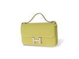 a yellow handbag with a metal handle on a white background
