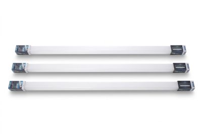 trois tubes fluorescents blancs posés sur une surface blanche éclairée par une lumière bleue