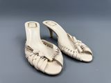 une paire de sandales en cuir blanc ornées d'un nœud au talon