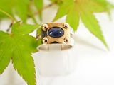 a picture of a ring with a blue stone on it