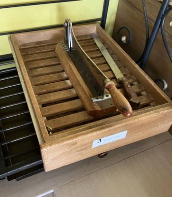 a wooden box with a knife and a pair of knives in it
