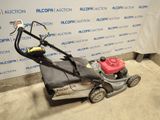 an image of a lawn mower parked in front of a wall