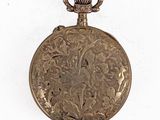 an antique pocket watch with a chain on a white background