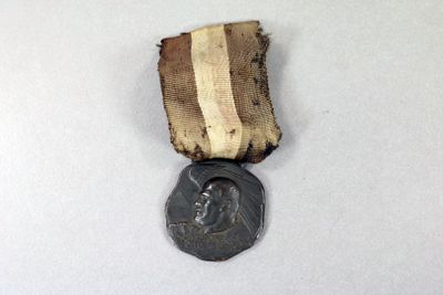 une vieille médaille en bronze posée sur un fond blanc