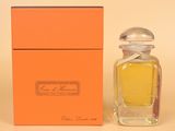 an orange box with a small bottle of perfume next to it