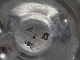 a metal bowl with holes in the middle of it