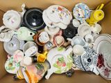 une boîte en carton remplie de nombreuses tasses à thé et soucoupes de toutes sortes