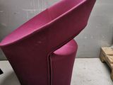 purple chair in a room with pallets on the floor and pallets on the wall