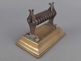 a small metal object on a stand on a table