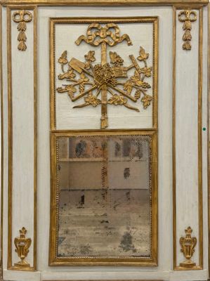 un miroir au milieu d'une armoire blanche aux bordures dorées