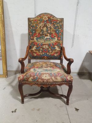 une vieille chaise dont le dossier est recouvert d'un tissu coloré et l'assise d'un tissu à motifs floraux