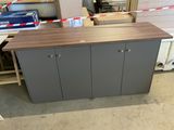 a wooden counter with two doors on it in a room