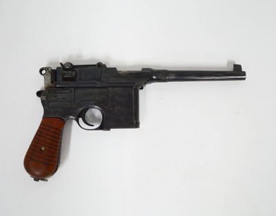 un vieux pistolet avec une poignée en bois sur une surface blanche