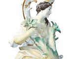a figurine of a woman sitting on a chair