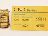 credit card with a gold bar next to it on a white surface