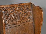 a wooden chair with a carved back and seat