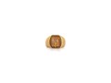 une image représentant une bague en or avec une pierre marron au centre