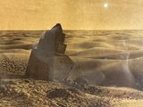 an old photo of a rock in the middle of the desert