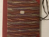 un vieux livre à la couverture rouge posé sur une table