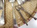 a lot of silver spoons and spoon spoons on a wicker tray