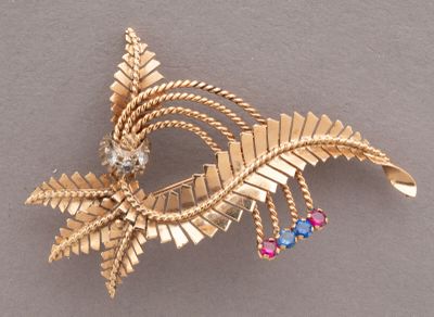 a gold brooch with colorful stones on it