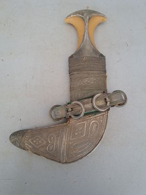a silver and gold object on a white surface