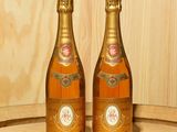 deux bouteilles de champagne posées sur un tonneau en bois