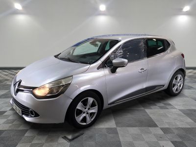une voiture argentée est garée dans une pièce au sol en damier
