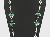un collier composé de perles vertes et blanches, présenté sur un mannequin
