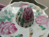 une assiette blanche ornée d'un motif floral rose et vert