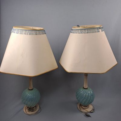une paire de lampes bleues et blanches posées sur une table, avec un abat-jour blanc