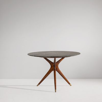 a round table with wooden legs and a black marble top
