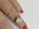a woman ' s hand with a red manicure and a diamond ring