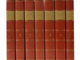 six red books are lined up in a row on a white surface