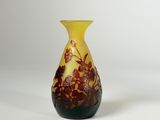 un vase jaune et noir posé sur une surface blanche