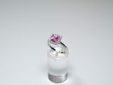 an image of a pink diamond ring sitting on top of a clear glass