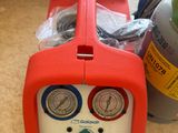a red and blue air compressor sitting on the floor