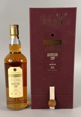 une bouteille de whisky posée sur une table à côté d'un coffret